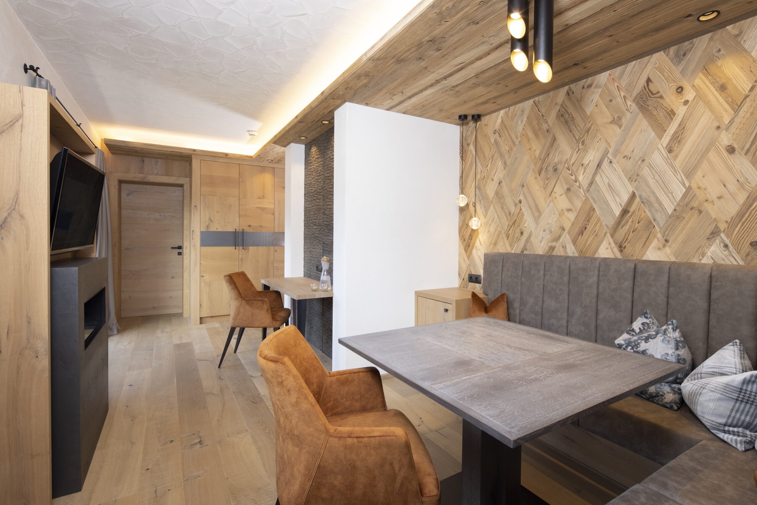 Modern eingerichtetes Esszimmer mit Holzverkleidung, einem Esstisch und Stühlen im gemütlichen Design.