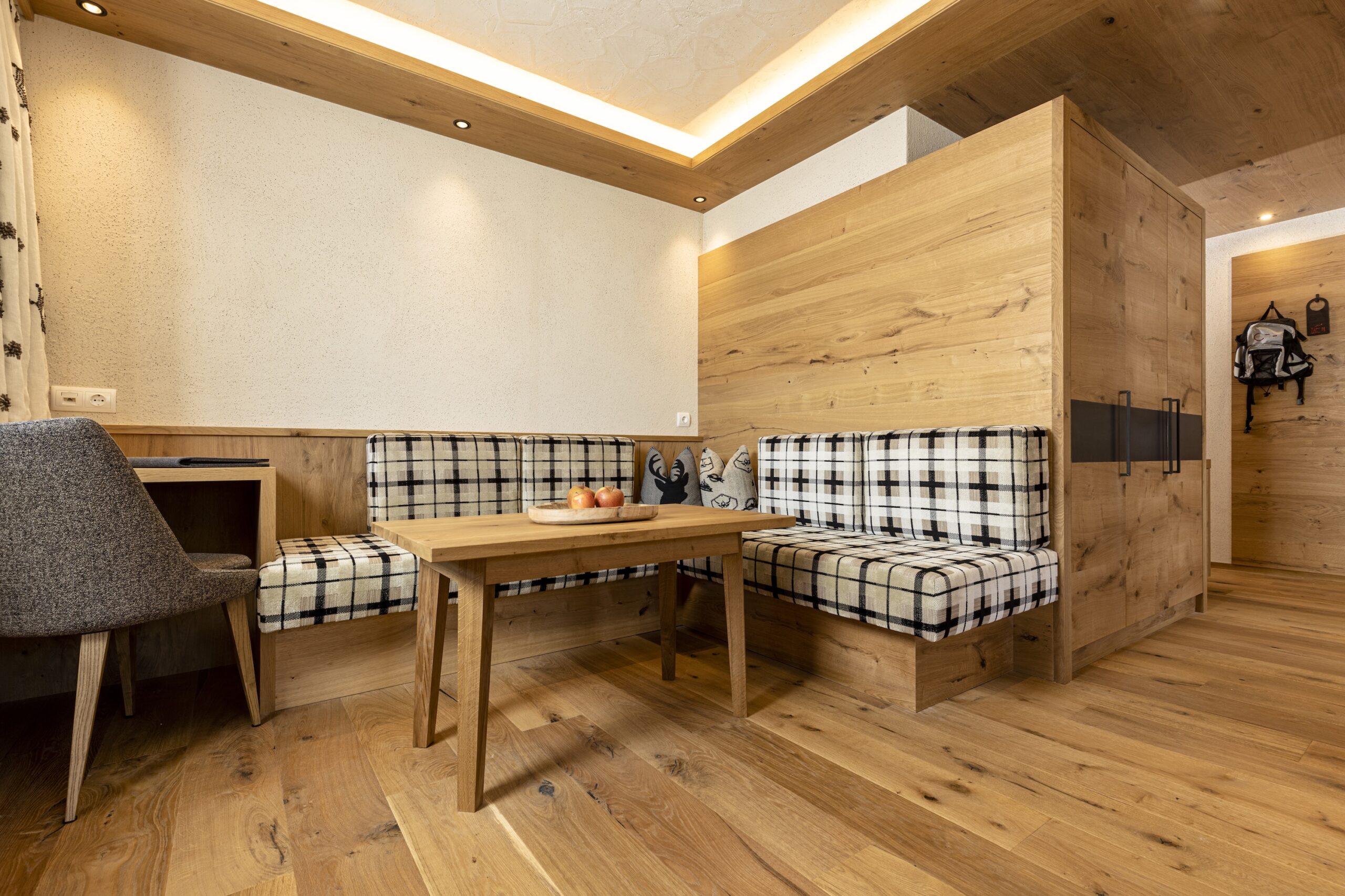 Modern eingerichtete Holzkabine mit einer gemütlichen Sitzecke, einem Esstisch und dekorativen Elementen in einem warm beleuchteten Raum.