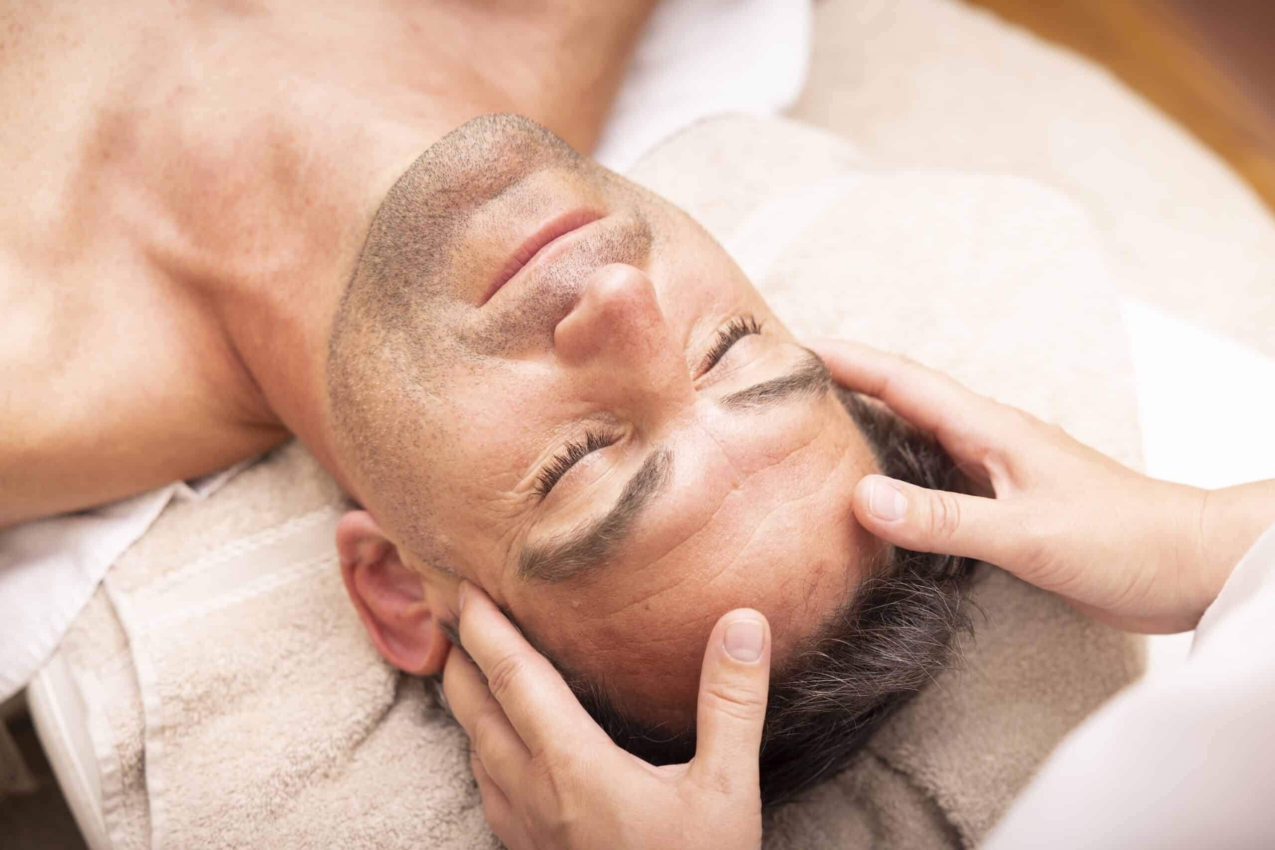 Ein Mann erhält eine entspannende Gesichtsmassage in einem Spa.