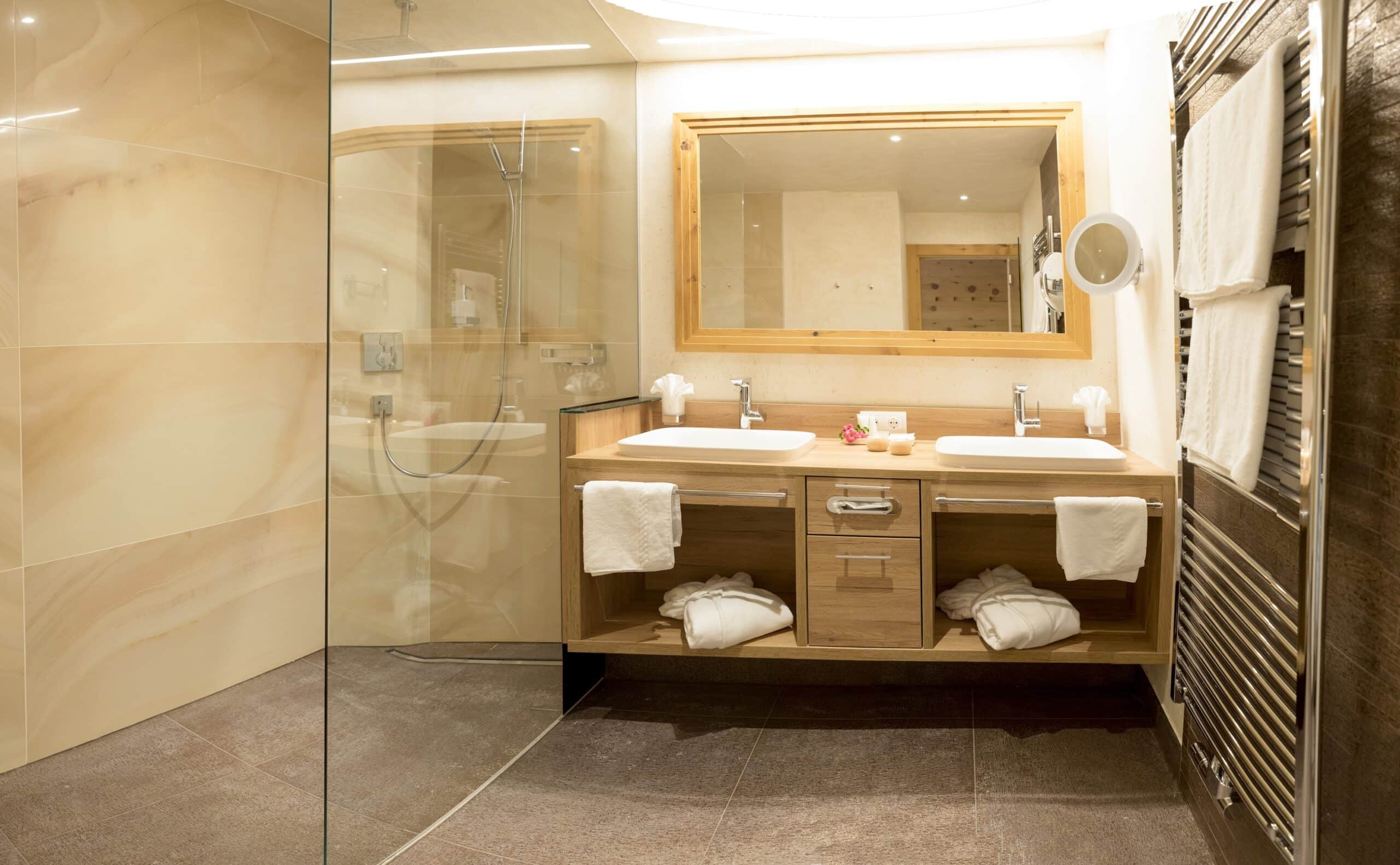 Modernes Badezimmer mit Doppelwaschtisch, großen Spiegeln und begehbarer Dusche.