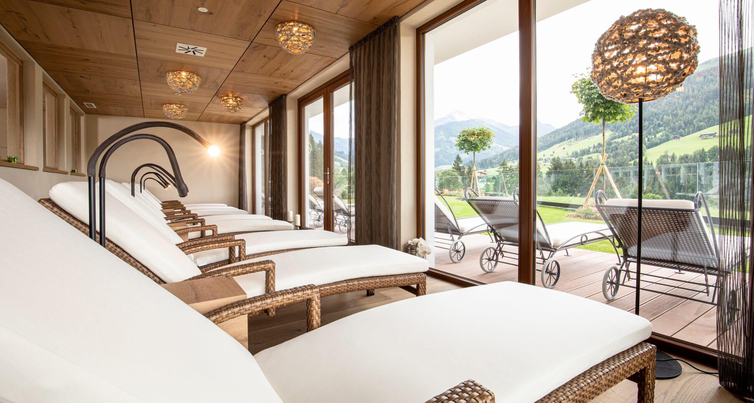 Ruhebereich mit gemütlichen Liegen im Wellnesshotel Tirol mit Panoramablick auf die Tiroler Alpen