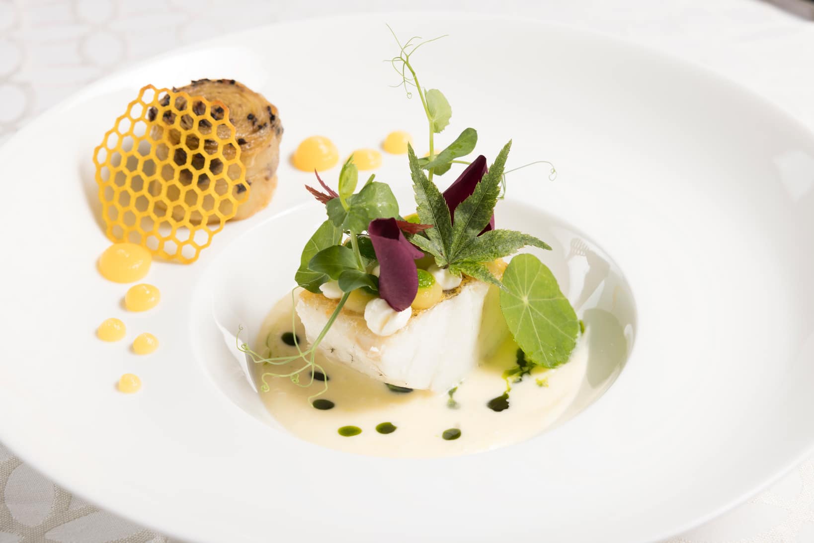 Teller mit Fisch und grün-roten Dekoblättern