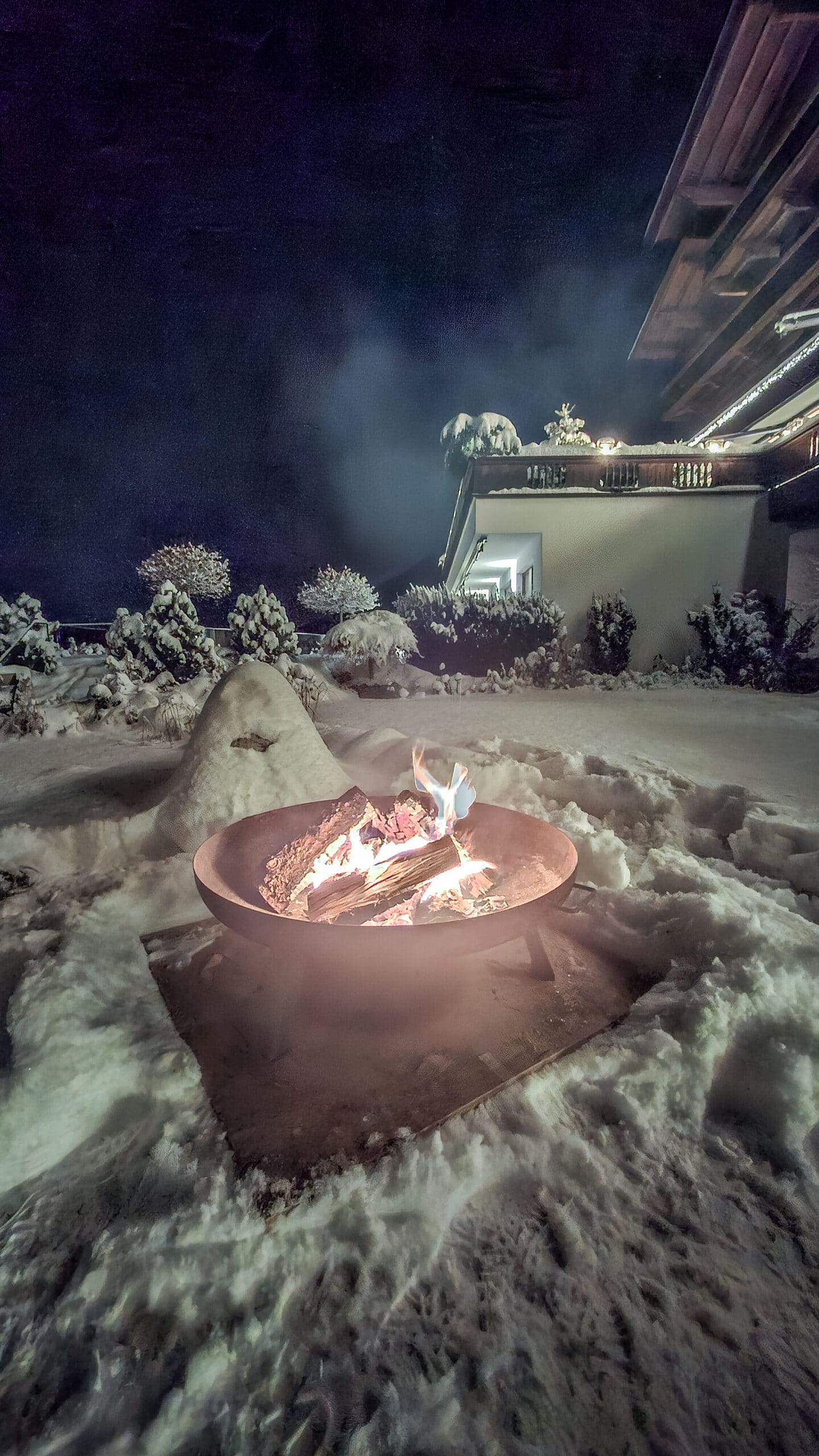 Feuerschale_entzündet im winterlichen Garten mit Blick zur Hotelterrasse