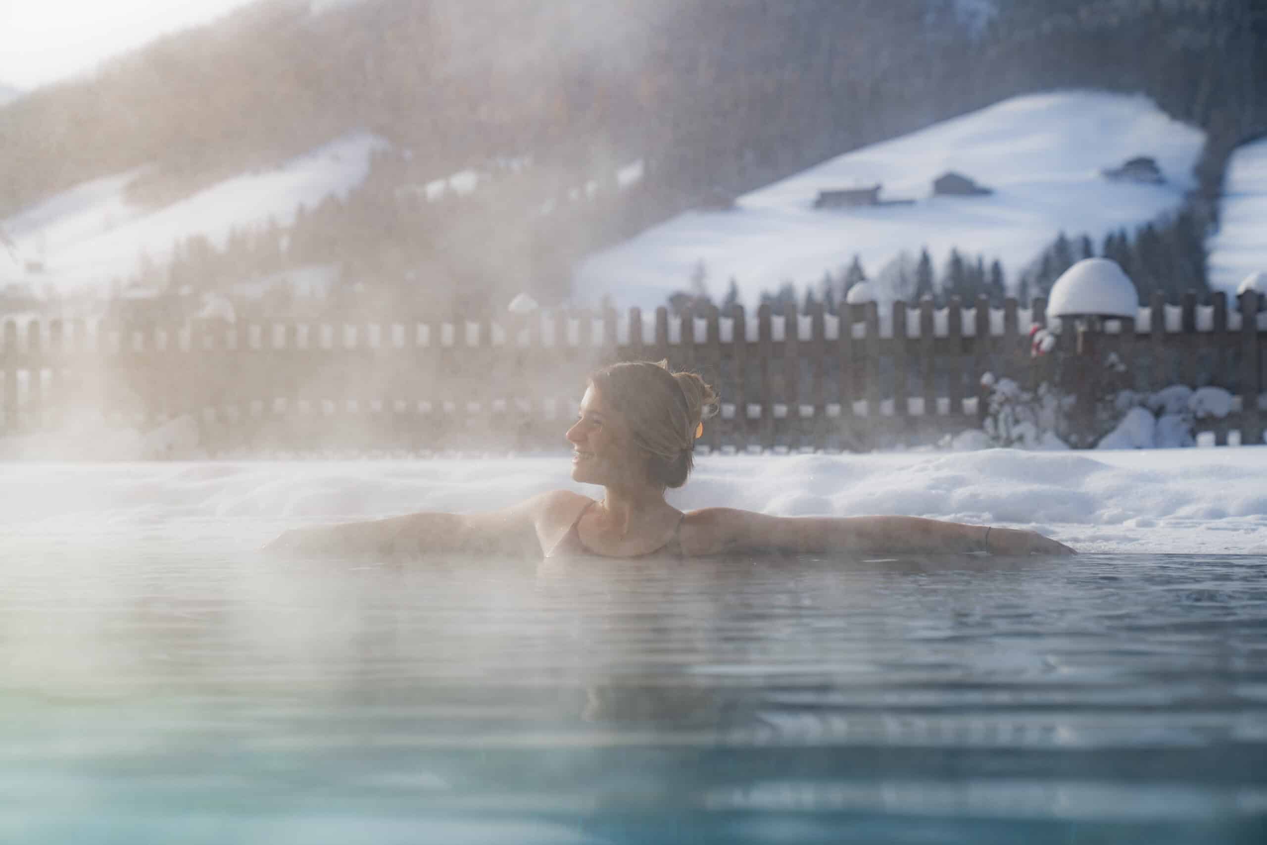 Frau entspannt im Outdoorpool des Wellnesshotels Alpbacherhof im Alpbachtal